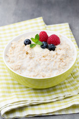 Oatmeal porridge in bowl with berries raspberries and blackberri