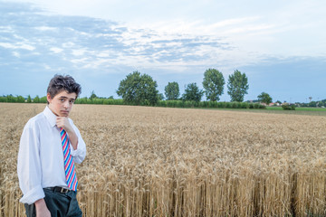 Naklejka na ściany i meble cute caucasian boy in a wheat field