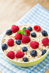 Oatmeal porridge with berries. Raspberries and blueberries.