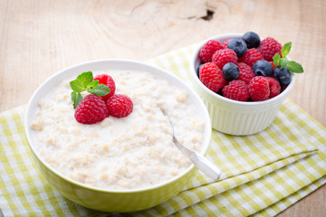 Oatmeal porridge in bowl with berries raspberries and blackberri