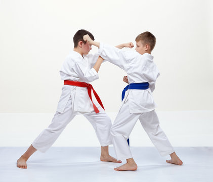 On a white background athletes train blocks and kicks of karate