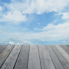 Naklejka na ściany i meble Empty old wood floor with blue sky with white clouds, for your p