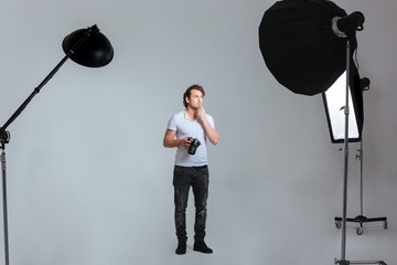 Pensive male photographer standing in professional studio © Drobot Dean