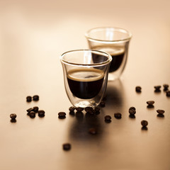 Espresso coffee in a transparent plate on a brown background