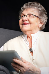 Babcia i komputer.Starsza kobieta serfuje po internecie. - obrazy, fototapety, plakaty