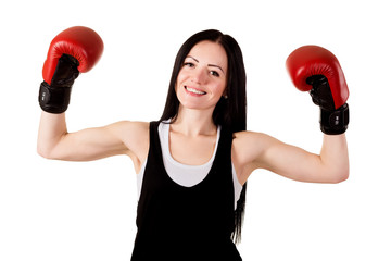 Smiling brunette girl with long hair in red boxing gloves raised her hands up