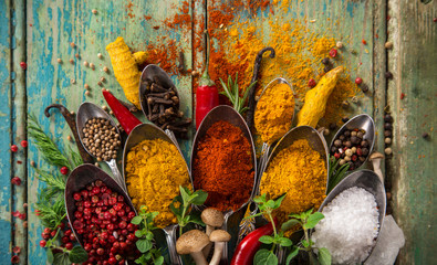 Various colorful spices on wooden table - obrazy, fototapety, plakaty