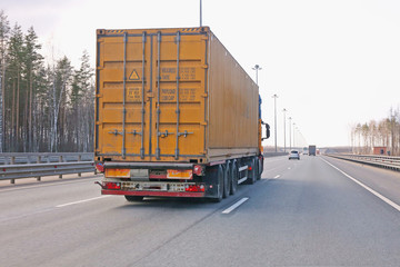 truck carries a heavy container on the road