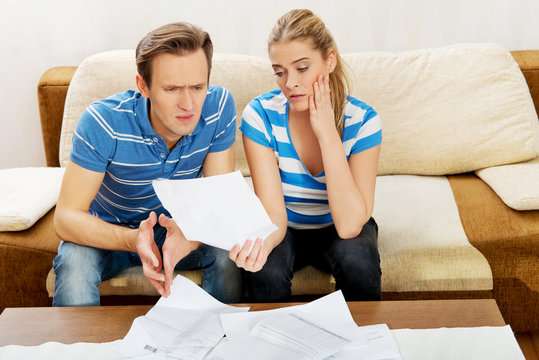 Worried couple after calculating bills sitting at home
