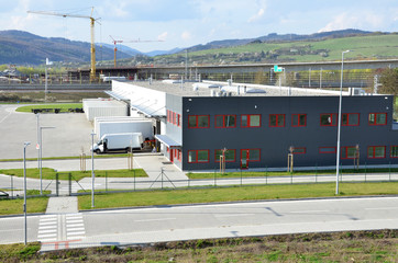 Logistics center, freight is uncharged from van. Tower cranes in background