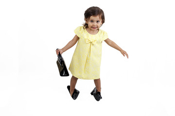 Girl wearing adult shoes and with bag  isolated on white background