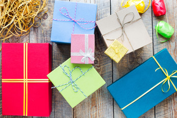 Colored gift boxes on wooden background with ribbons