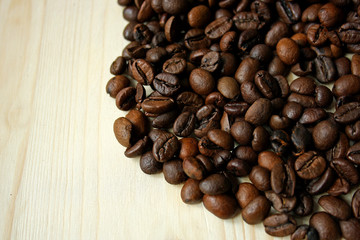 Coffee beans on wooden surface.