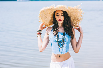 beautiful girl on the lake in big hat