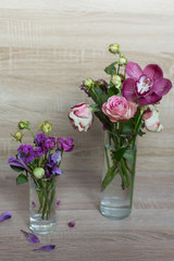 spring bouquet of flowers in a glass vase rose pink orchid on a wooden background