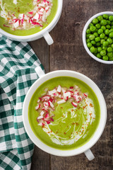 Pea cream with radishes on a rustic wooden background
