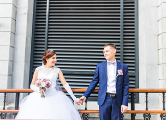 Bride and groom holding hands outdoors.