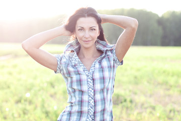 Girl in plaid shirt summer  meadow, concept the idea of happiness brunette rest nature