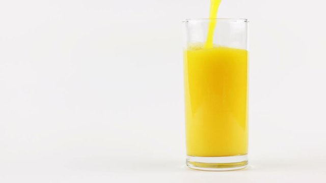 Man pouring orange juice into a glass on a white background