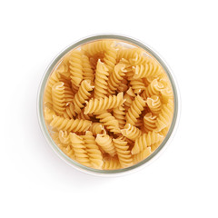 Glass jar filled with dry rotini pasta over isolated white background