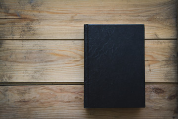 black book on a wooden table