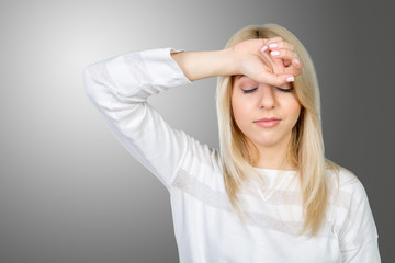 Depressed mature woman touching forehead and keeping eyes closed