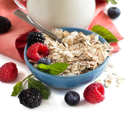 Rolled oats in a bowl with berries and milk
