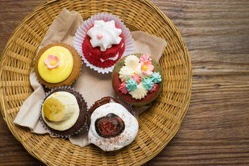 Mixed cupcakes on wood table.