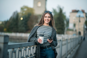 girl walking with coffee and phone