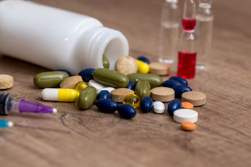 pills and syringe on desk