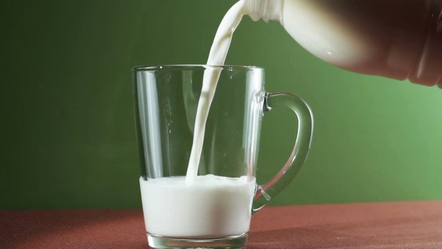Panning of milk pouring into an empty glass