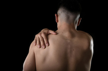 Naklejka premium young muscular sport man holding sore shoulder in pain touching massaging in workout stress