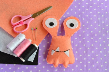 A cute felt monster, kids crafts. Scissors, threads, needles - sewing set for children's toy