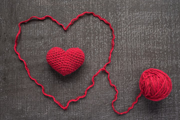 Crocheted red heart on a grunge board