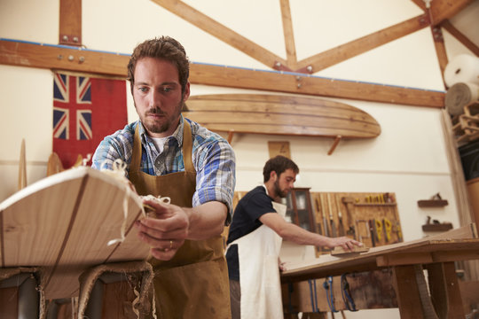 Men Building Bespoke Wooden Surfboard In Workshop - Powered by Adobe