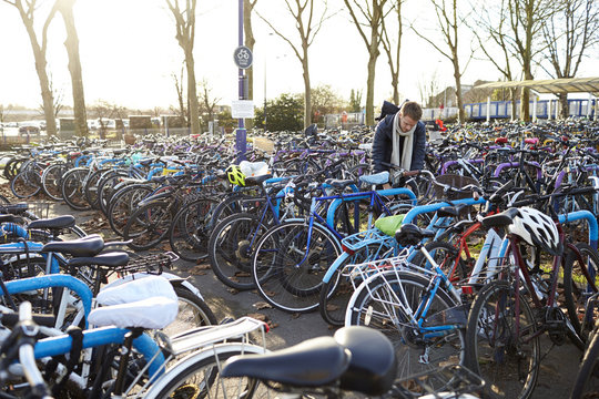 Man parking his bicycle in parking lot at railway station