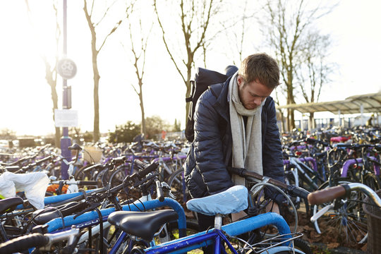 Man parking his bicycle in parking lot at railway station