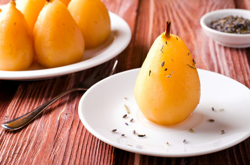 Poached pears with lavander on white plate