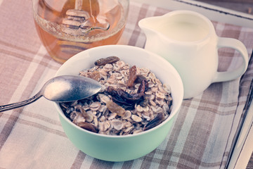oatmeal with honey and milk for breakfast on rustic wooden table.