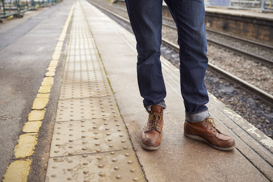 Detail Of Man Standing On Railway Platform Waiting For Train