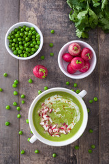 Pea cream with radishes on a rustic wooden background
