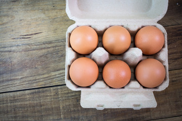 Eggs in paper tray on wood background