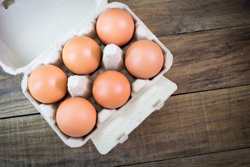 Eggs in paper tray on wood background