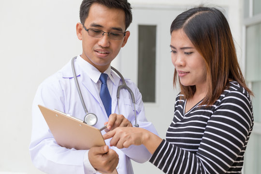Doctor holding application form while consulting patient
