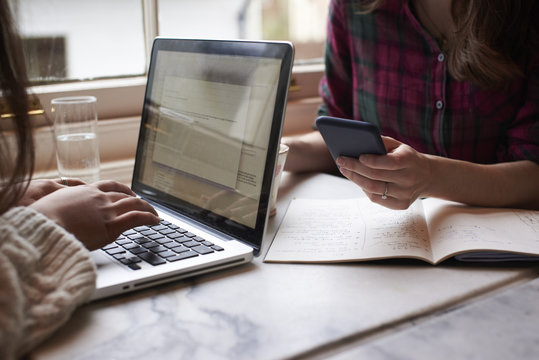 Close Up Of Two People Working Remotely In Caf&eacute;