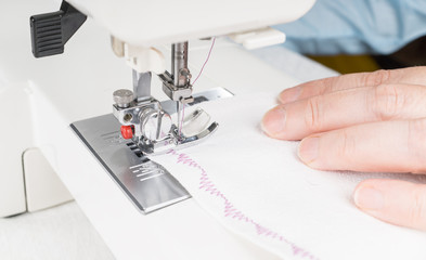 Seamstress using sewing machine, close-up