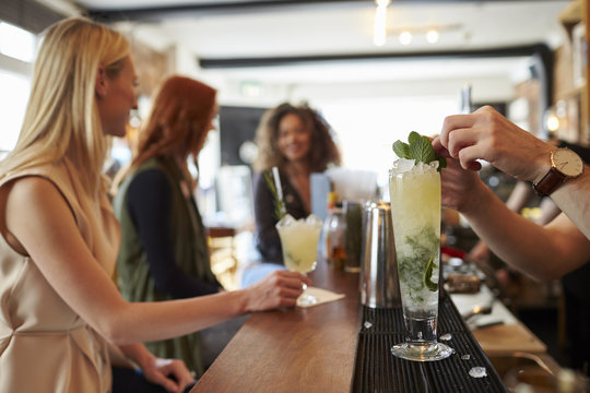 Barman Making Mojito Cocktail With Customers In Background