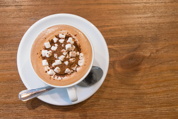 Top view of hot milk chocolate with marshmallows on wooden table