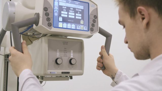 Young doctor moving xray machine