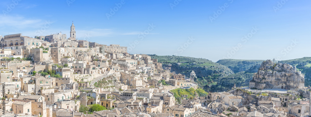 Wall mural panoramic view of typical stones (Sassi di Matera) and church of Matera UNESCO European Capital of Culture 2019 under blue sky